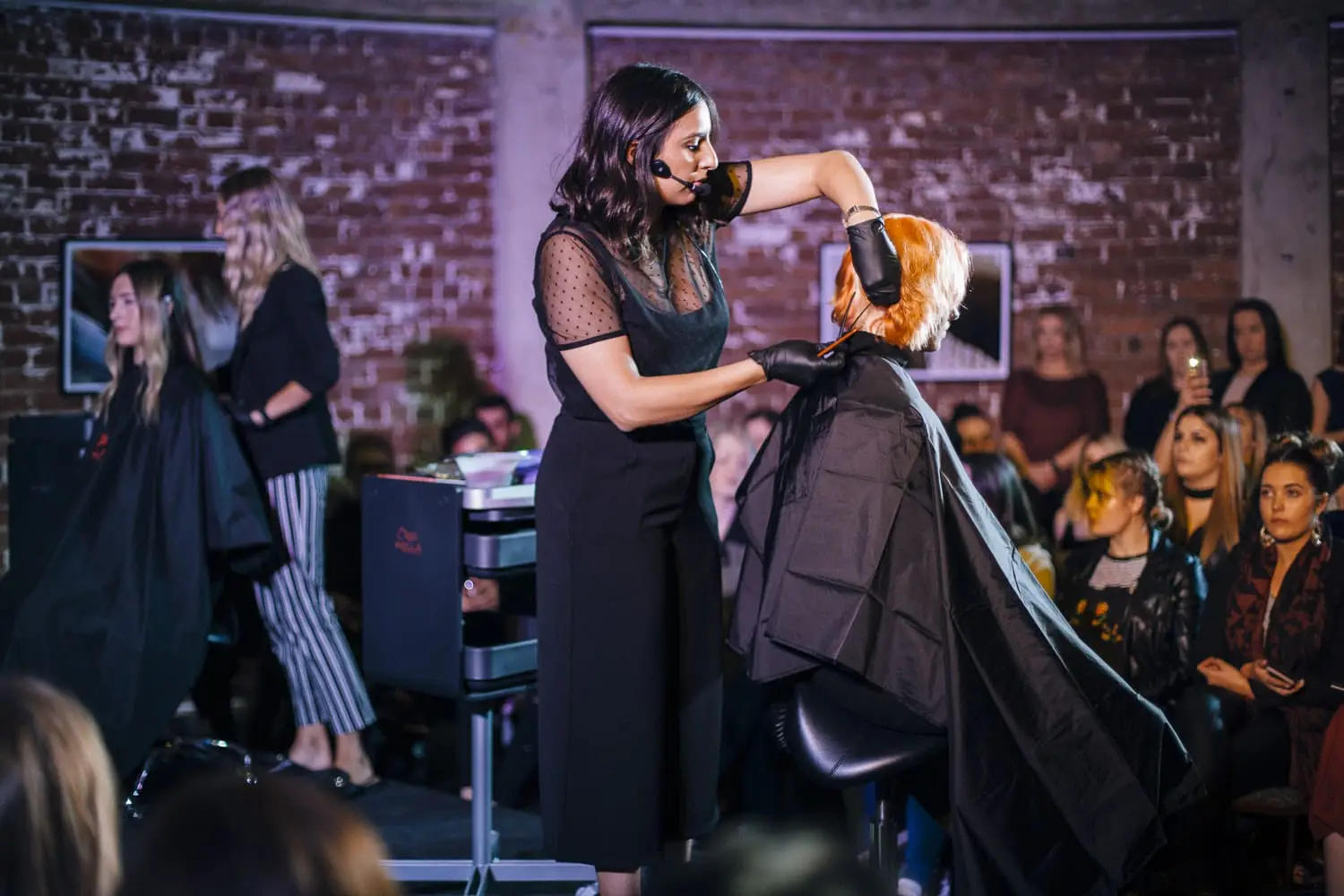 Christina, a celebrated Melbourne-based hair educator with over 13 years of expertise, demonstrates advanced hair coloring techniques on stage at a professional development seminar. As the head colourist and guest artist educator, she skillfully completes a trendy look on a model, showcasing her acclaimed skills in color personalization and efficiency. This event highlights her commitment to elevating hairdressing artistry and education in Melbourne, making it a must-attend for local hairdressers seeking to upskill and learn new trends